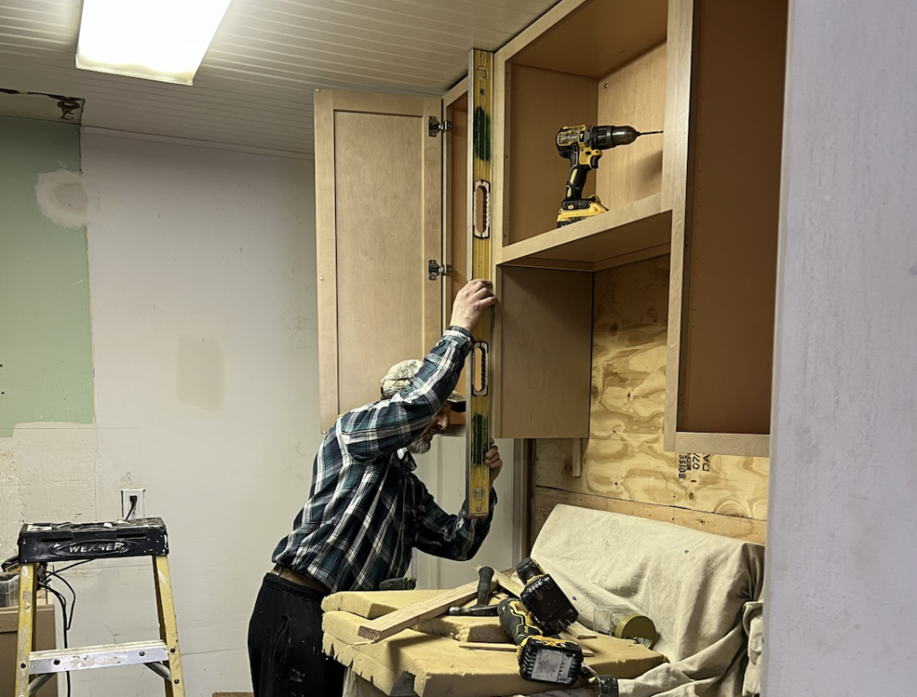 A man working on a cabinet replacement